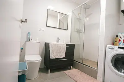 a bathroom with a sink toilet and a washing machine at Cotonat in El Arrabal