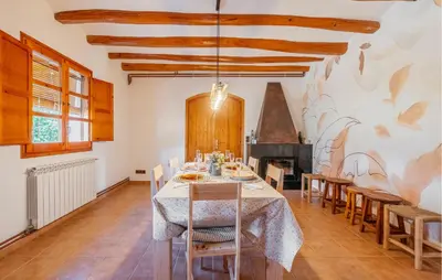 a dining room with a table and chairs and a fireplace at Beautiful Home In Guardiola De Fontrubí in La Guardiola