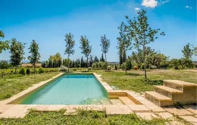 a pool in the middle of a field with trees at Beautiful Home In Guardiola De Fontrubí in La Guardiola
