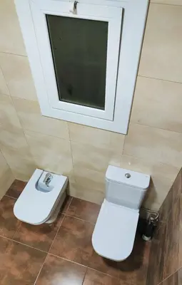 a bathroom with a toilet and a tv on the wall at Apart Granollers Centre in Granollers