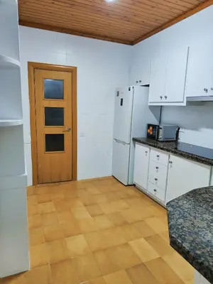 a kitchen with white cabinets and a wooden door at Apart Granollers Centre in Granollers