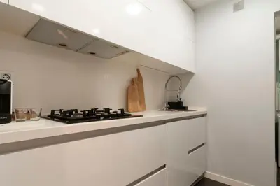 a white kitchen with a stove and a sink at Opening Doors Poblenou Beach in Barcelona