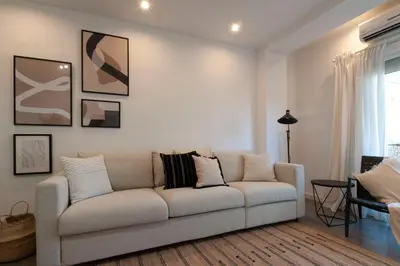 a white living room with a couch and a table at Opening Doors Poblenou Beach in Barcelona