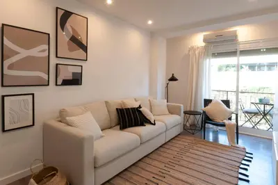 a living room with a white couch and a window at Opening Doors Poblenou Beach in Barcelona