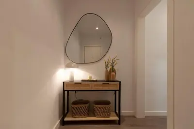 a mirror on a wall next to a table with baskets at Opening Doors Poblenou Beach in Barcelona