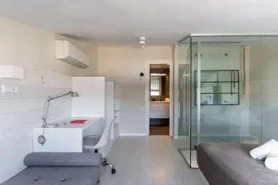 a bedroom with a bed and a desk and a shower at Penthouse with private terrace in the center in Barcelona