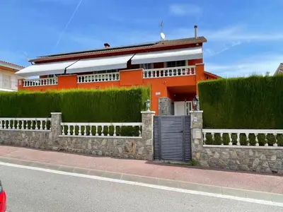 an orange building with a gate in front of it at Casa de vacances Mary in Santa Eulalia de Ronsaná