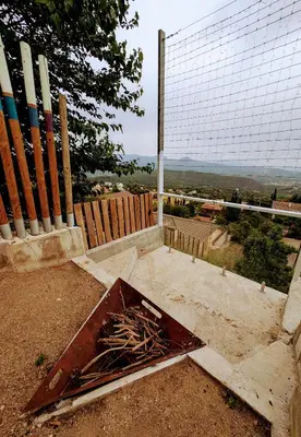 a metal box sitting on the ground next to a fence at AranEtxea in Bigues i Riells