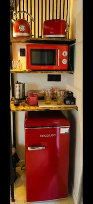 a microwave sitting on top of a red refrigerator at Apart con terraza en Florida E2 in Hospitalet de Llobregat