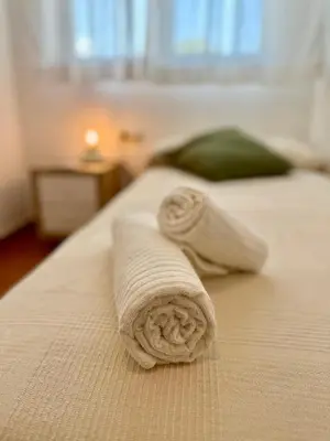 a rolled up towel sitting on a bed at Apartamento St Agustí - Centric in Mataró