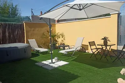 a patio with an umbrella and chairs and a table at Casa Salud in Piera