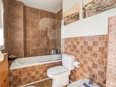 a bathroom with a toilet and a bath tub at Panoramic Terraces by Hello Homes Sitges in Sitges