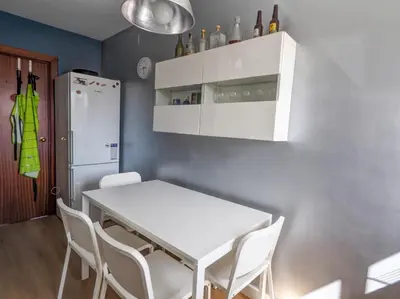 a kitchen with a white table and chairs and a refrigerator at Panoramic Terraces by Hello Homes Sitges in Sitges