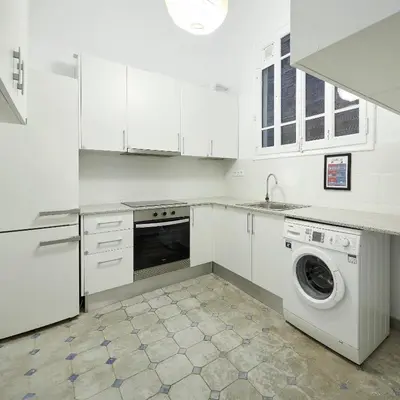 a white kitchen with a washing machine and a washer at Girona 46 - 1 in Barcelona