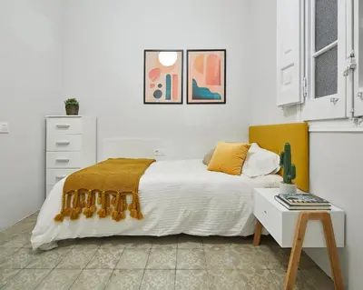 a white bedroom with a bed and a table at Girona 46 - 1 in Barcelona