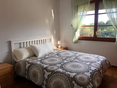 a bedroom with a bed and a window at Casa Fontanals in Pla del Panadés