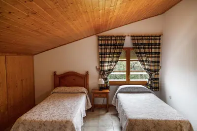 two beds in a room with a window at Casa Fontanals in Pla del Panadés