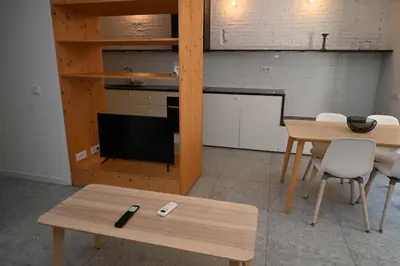 a living room with a table and a tv at Homenfun Barcelona Hospital Clínic l in Barcelona