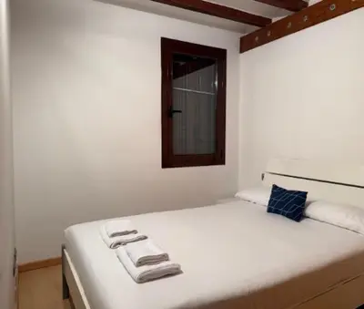a white bed in a room with a window at Homenfun Barcelona Hospital Clínic l in Barcelona