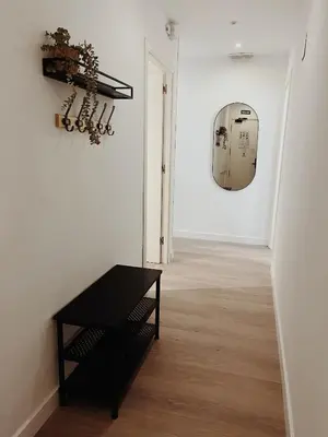 a hallway with a black table and a mirror at Apartamentos Express by gaiarooms in Barcelona