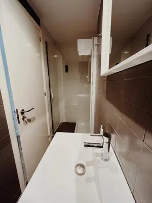 a bathroom with a white sink and a shower at Apartamentos Express by gaiarooms in Barcelona