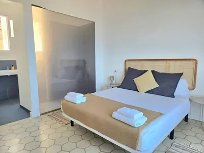 a bedroom with a bed with blue and yellow pillows at Casa Mas Blau | Increíbles vistas frente al mar in San Pol de Mar
