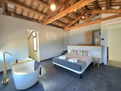a bedroom with a tub and a bed and a bathtub at Casa Mas Blau | Increíbles vistas frente al mar in San Pol de Mar