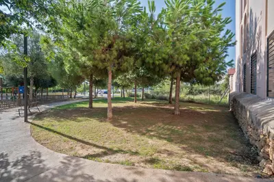 a group of trees in a park next to a building at Sitges Spaces Garden Condo-2 Bedrooms, 2 Bathrooms, Garden Terrace, Near center, Sleeps up to 6- Monthly Rentals Only in Sitges