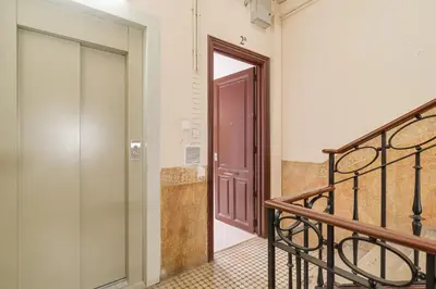 a hallway with a wooden door and a staircase at GuestReady - Lovely home in the heart of Barcelona in Barcelona