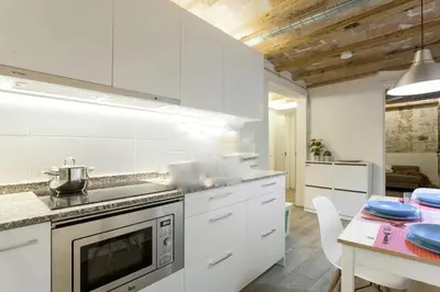a kitchen with white cabinets and a table with blue dishes at Barcelona Classic Palau Apartments in Barcelona