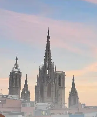 a cathedral with two towers and a clock tower at Room in Gotic in Barcelona