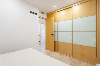 a bedroom with a wooden closet and a bed at Cozy Apartment II - Les Corts in Barcelona