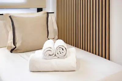a pile of towels sitting on top of a bed at Cozy Apartment II - Les Corts in Barcelona