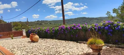 a garden with purple flowers and a fence at Ànima del Garraf in Sitges