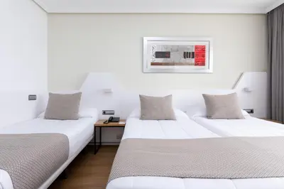 two beds in a room with white walls at Alexandre FrontAir Congress in Sant Boi del Llobregat