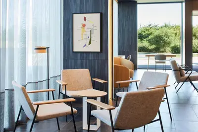 a waiting room with chairs and a clock on the wall at Four Points by Sheraton Barcelona Airport in Barcelona