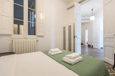 a white bedroom with two towels on a bed at BP2 - Big apartment for groups in BCN city center HUTB - 77390 in Barcelona