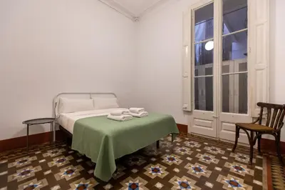 a bedroom with a bed with a table and two chairs at BP2 - Big apartment for groups in BCN city center HUTB - 77390 in Barcelona