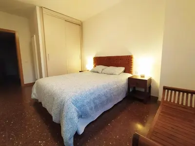 a bedroom with a bed and a night stand with a lamp at Spacious apartment in the heart of the city in Barcelona