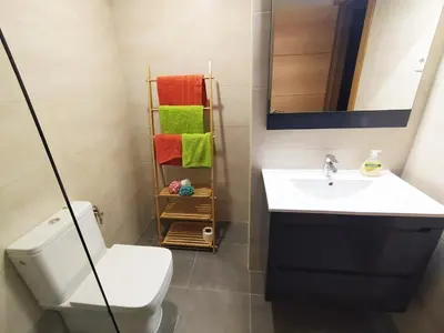 a bathroom with a sink and a toilet and a mirror at Spacious apartment in the heart of the city in Barcelona
