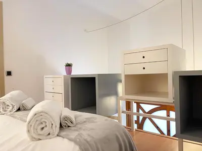 two twin beds in a room with a table at Duplex in Gracia in Barcelona