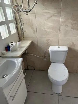 a bathroom with a white toilet and a sink at Hidden Garden Haven for 7 People in Vallromanas