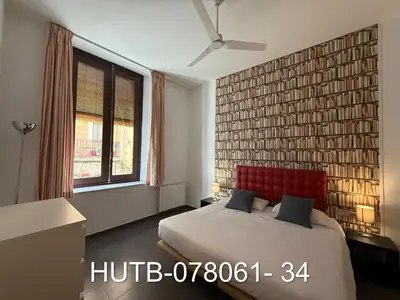 a bedroom with a bed with a red headboard and a window at Palau de la música 1 in Barcelona