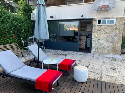 a patio with two chairs and an umbrella and a table at Apartamento con piscina y barbacoa cerca de Barcelona in Teià