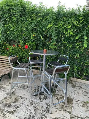 three chairs and a table with a cup on it at Apartamento con piscina y barbacoa cerca de Barcelona in Teià