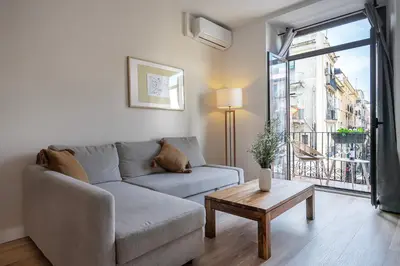 a living room with a couch and a table and a window at Happy Apartments in Barcelona