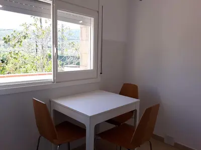 a white table and chairs in a room with a window at Alt Penedes, terra de vinya, sol, aigua i muntanya in Torrellas de Foix