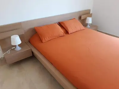 an orange bed with two pillows and two lamps at Alt Penedes, terra de vinya, sol, aigua i muntanya in Torrellas de Foix