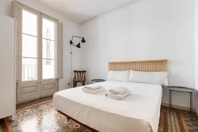 a bedroom with a large white bed with two towels on it at B41 - Apartamento para grandes grupos en BCN centro in Barcelona