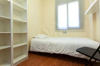 a bedroom with a bed and a window and shelves at Apartment near the beach Pujades in Barcelona